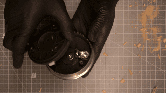 나무 조각품과 기계 부품을 조립하는 손