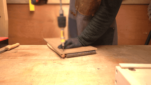 나무 판자에 드릴을 사용하는 사람