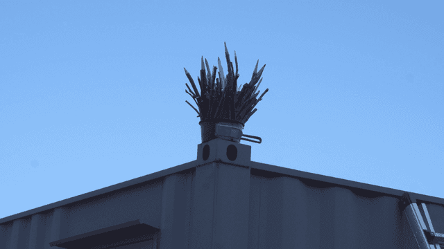 지붕 위에 놓인 나뭇가지 연필 조각품