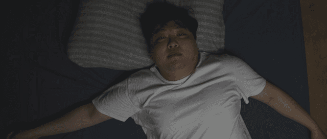 침대에 누워 있는 사람