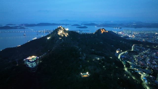 Cityscape with illuminated mountains at dusk