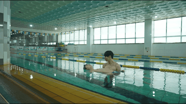 Two men practicing swimming in a pool