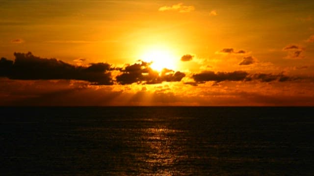 Sunset over Ocean Horizon with Clouds