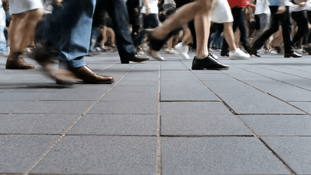 Legs of people walking on busy street