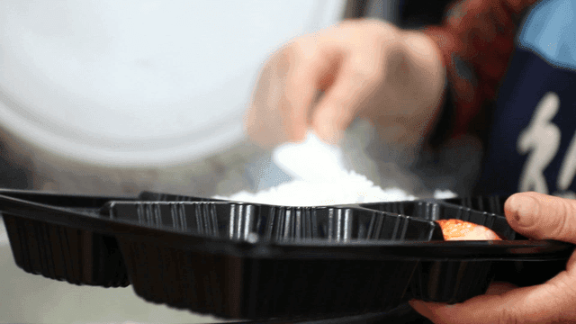 Steaming rice being served in a tray