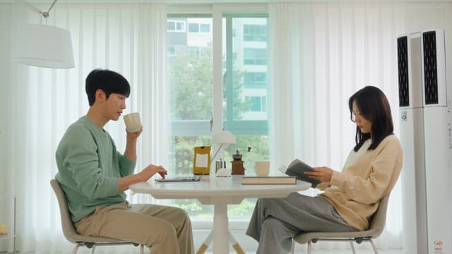 밝은 거실에 앉아서 휴식을 즐기는 커플