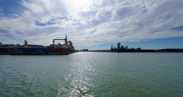 파란 하늘 아래 바다 근처에 위치한 산업단지