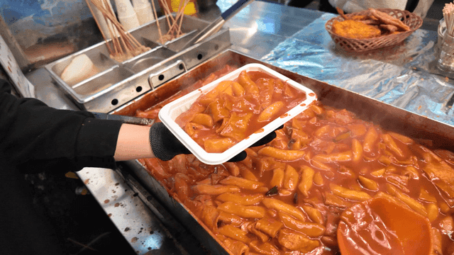 Serving tteokbokki in a street food stall