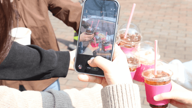 Friends taking a photo with iced drinks