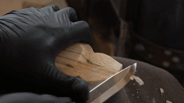 칼로 정교하고 세심하게 나무를 조각하는 손