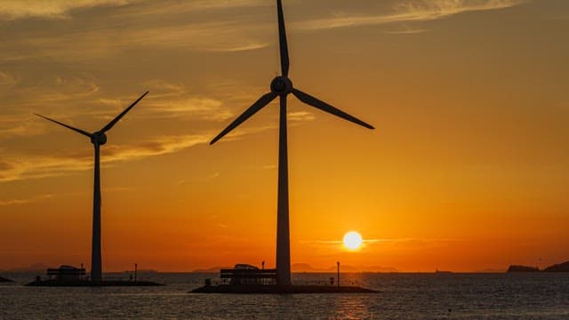 풍력발전기가 있는 바다 위 붉은 노을