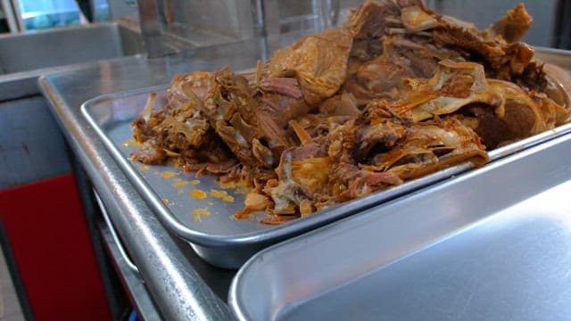 Steamed meat pieces on a metal tray in a kitchen