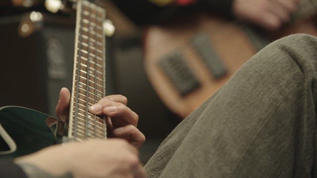 실내에서 기타를 연주하는 사람들