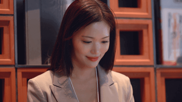 Female office worker smiling while looking down in office