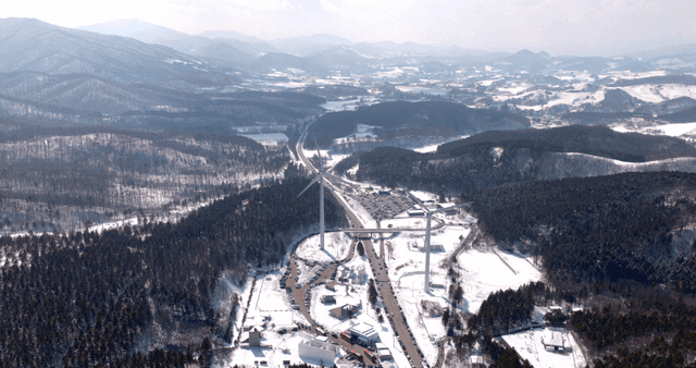 Snow-covered mountains with wind turbines