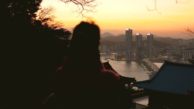 일몰에 도시를 내려다보는 사람의 실루엣