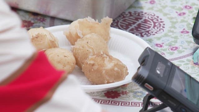 Hand Peeling Boiled Potatoes on a Plate