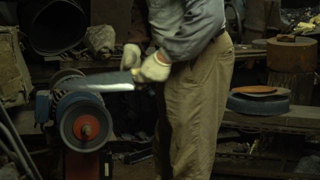 Worker sharpening a blade in a workshop