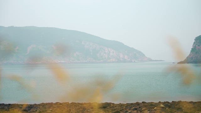 Calm Waterside with Blurry Mountain Views