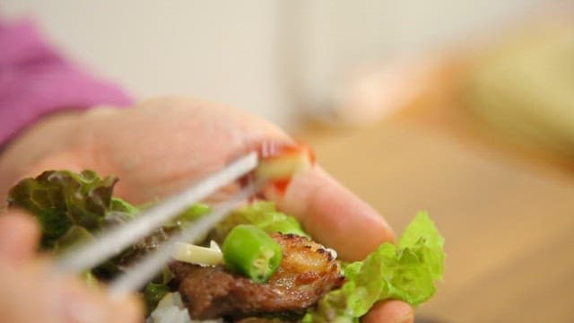 Wrapping grilled marinated pork ribs and garlic in lettuce