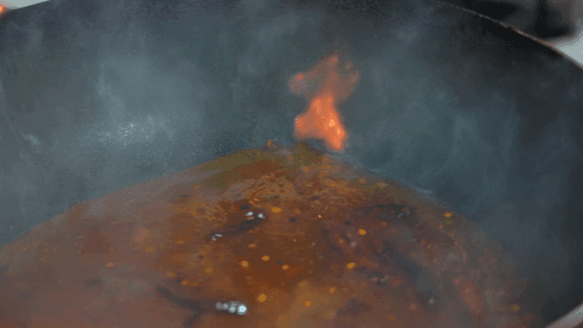 Spicy chili broth boiling with flames