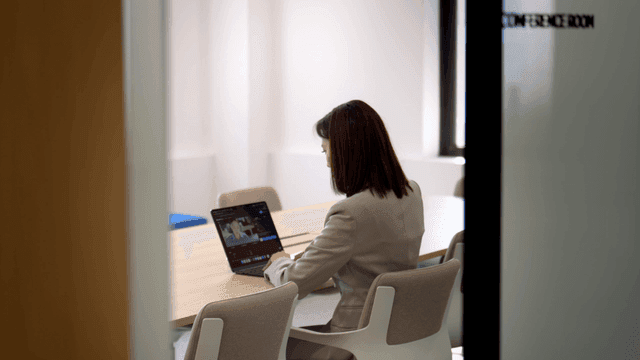 Female office worker working on laptop in conference room