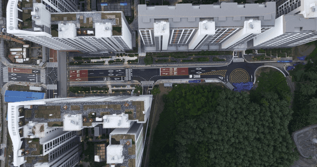 High-rise apartment complex with forest and road