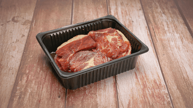 검은 플라스틱 접시에 담긴 신선한 양념 돼지고기