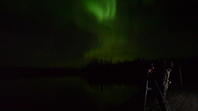 밤하늘에 뜬 오로라를 촬영하는 사람
