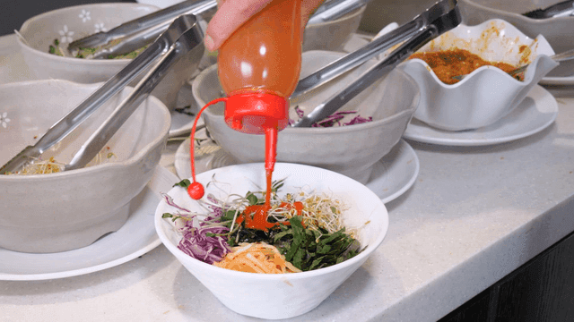 Vegetable bibimbap with sauce poured over it