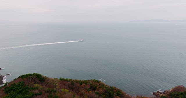 해안선 근처 조용한 바다를 항해하는 배