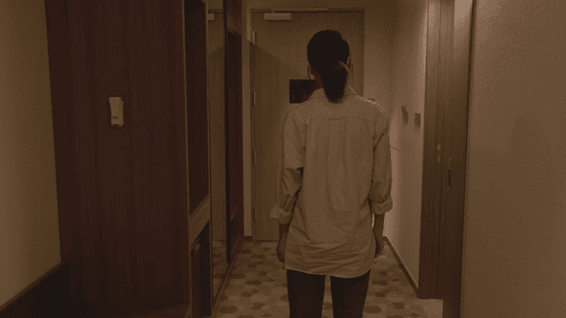 호텔 현관을 바라보는 여성의 뒷모습