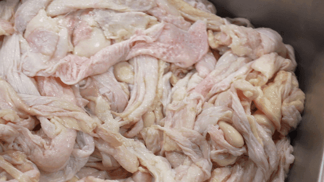 Raw chicken intestines in a metal tray