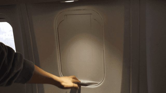 Hand closing airplane window shade