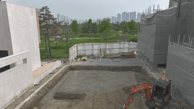 Construction site with excavator and buildings