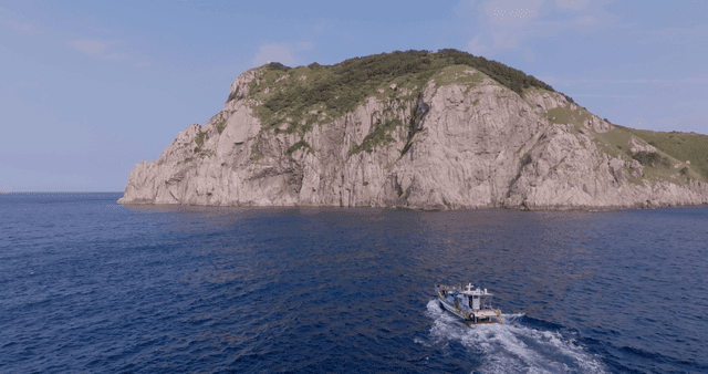 A boat approaching a rocky island