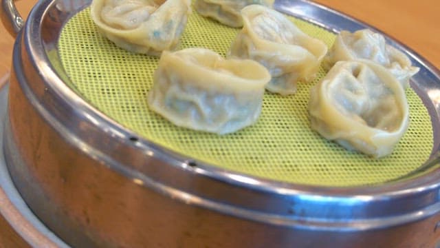 Steamed dumplings plated in a steamer on the table