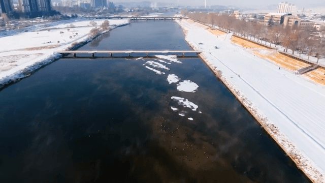 도시 건물이 보이는 눈 덮인 강변