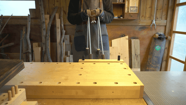 브래킷이 연결된 나무 공예품을 흔드는 장인