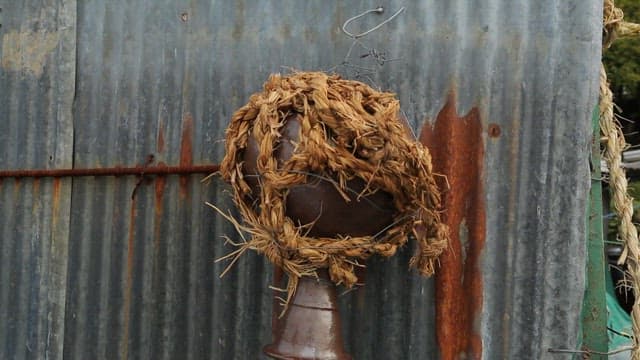 A rustic structure adorned with natural and straw decorations.