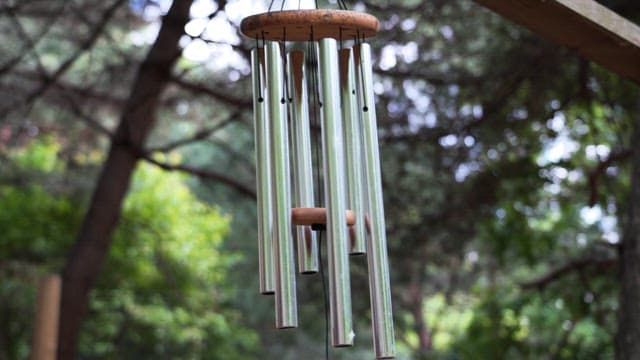 Outdoor wind chime gently swaying amidst the trees