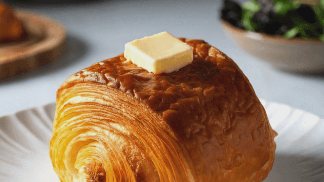 Croissant with butter on plate