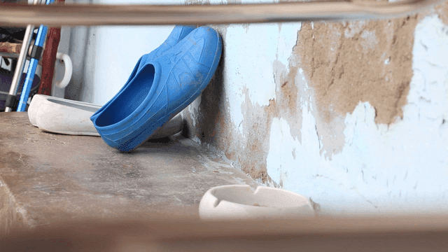 Blue rubber shoes on a worn-out porch