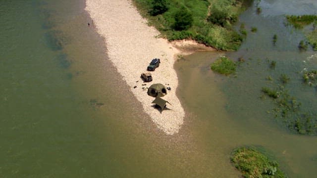 강가에 설치된 텐트와 차량들