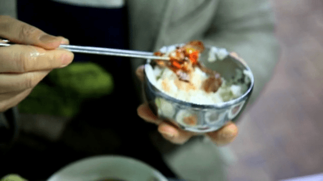 굴무침을 밥에 올리는 모습