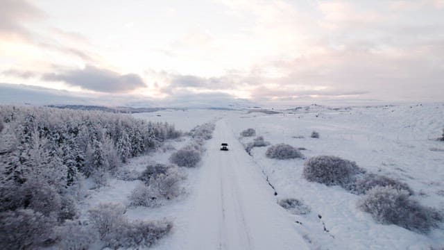 Car driving through a snowy landscape