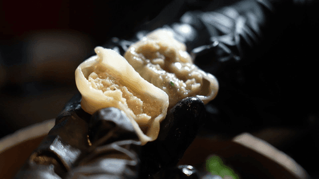 Steaming dim sum held in gloved hand