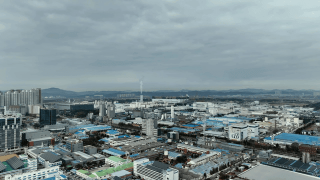 Industrial city landscape spread out beneath cloudy sky