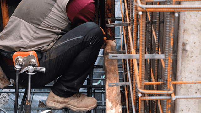 Worker securing steel bars at a construction site