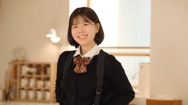 Female student smiling at home while carrying bag